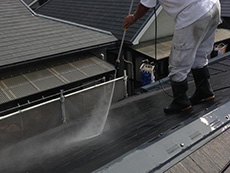 大山崎町の屋根外壁塗装リフォーム。塗料の密着を良くするために、屋根を高圧洗浄機で洗っています。これはとても重要な作業です。