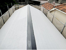 大山崎町の外壁屋根塗装リフォーム。屋根が白色に塗られています。これは塗料がしっかり密着するように、接着剤のような下塗り材を塗ったからです。