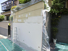 ライオンホームの塀塗装リフォーム。花壇から染み出る水を外へ通す為に、リシンを吹き付けています。