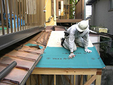 ライオンホームでリフォーム。浴室の屋根を葺き替えています。緑の防水シートを敷き、上から屋根材を施工します。