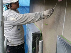 西京区の外壁塗装外構リフォーム。外壁1回目を手塗ローラーで塗っています。次に塗る塗料の密着を高める為の下塗り材です。