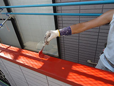 ライオンホームで外壁塗装。バルコニーの手すりに赤色の錆止め材を塗っています。手すりは鉄板で出来ている為、錆びないように下処理をしなければいけません。