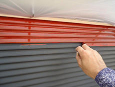 ライオンホームで外壁塗装。雨戸にも錆止めを塗っています。雨戸の波型のパネルはスチール製なので錆止めをしっかり塗ります。