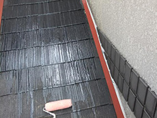 長岡京市の外壁屋根塗装リフォーム。屋根に下塗り材を塗っています。乾くと透明になっています。