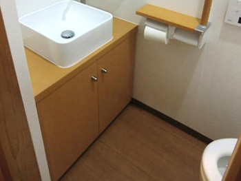 長岡京市のライオンホームでトイレリフォームをしました。リフォーム後のトイレ内です。トイレ室が30ｃｍ広くなりました。広げた部分にはオリジナルのカウンターキャビネットを設置して、その上にサンワカンパニーの手洗い器を取り付けました。