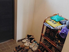 大山崎町のマンションリフォーム。リフォーム前の玄関に靴がたくさん並んでいます。収納場所がありません。