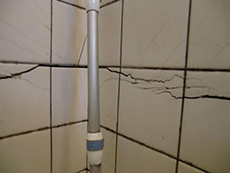 大山崎町の浴室・洗面室リフォーム。過去の震災で入ったお風呂のタイル壁のひび割れです。このひび割れから水が漏れて、柱や土台を腐らせたりシロアリが発生する原因になります。