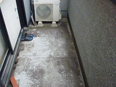 長岡京市の外壁塗装リフォーム。リフォーム前のベランダです。床が汚れています。防水加工を施工するため、室外機を移動させてから高圧洗浄機で汚れを落とします。