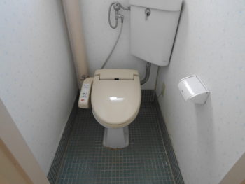 大山崎町の中古円団マンションリノベーション。ウォシュレットの付いた洋式トイレです。床がタイル貼りになっています。